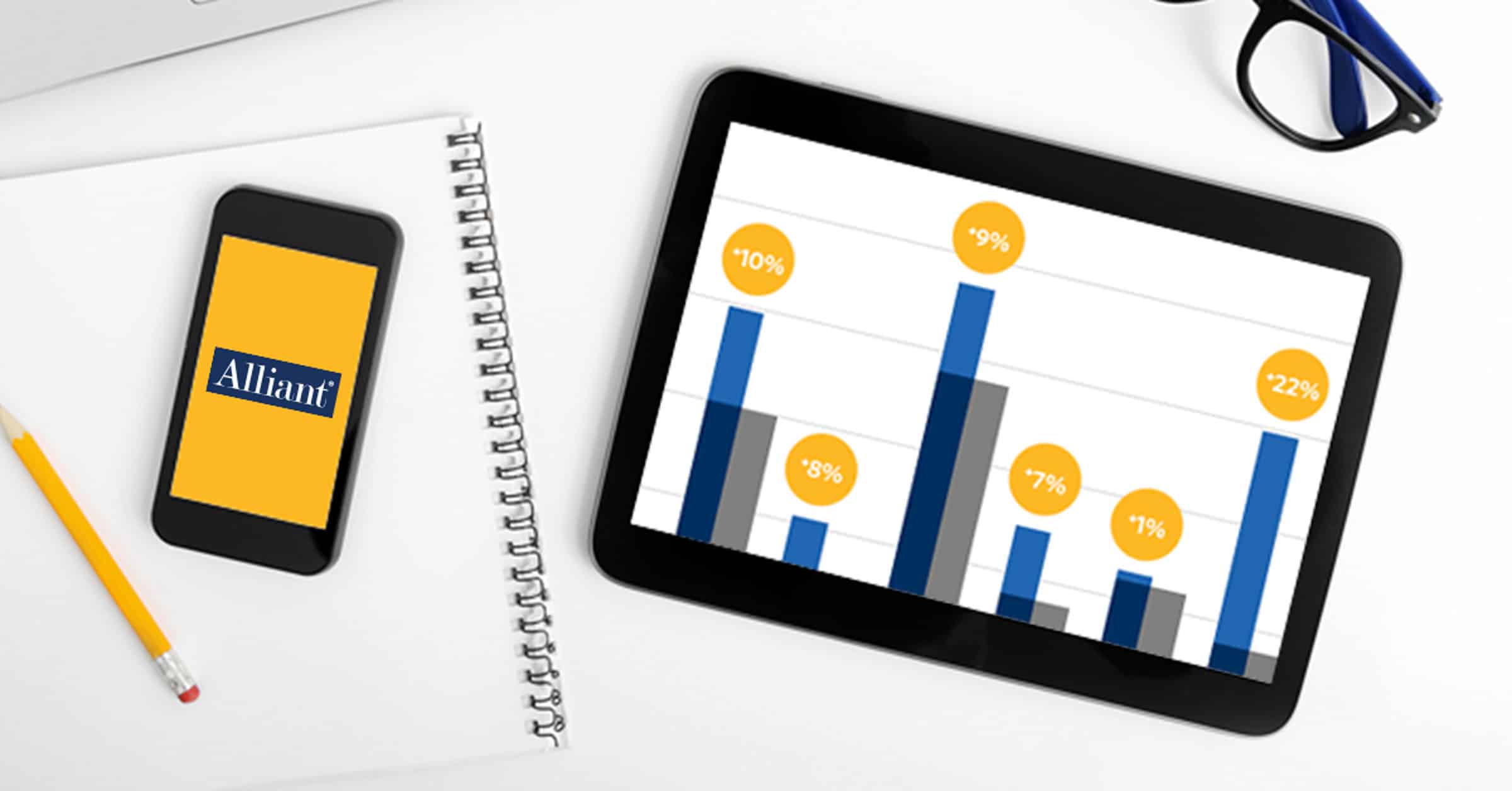 phone on a notepad with pencil and ipad with bar graphs